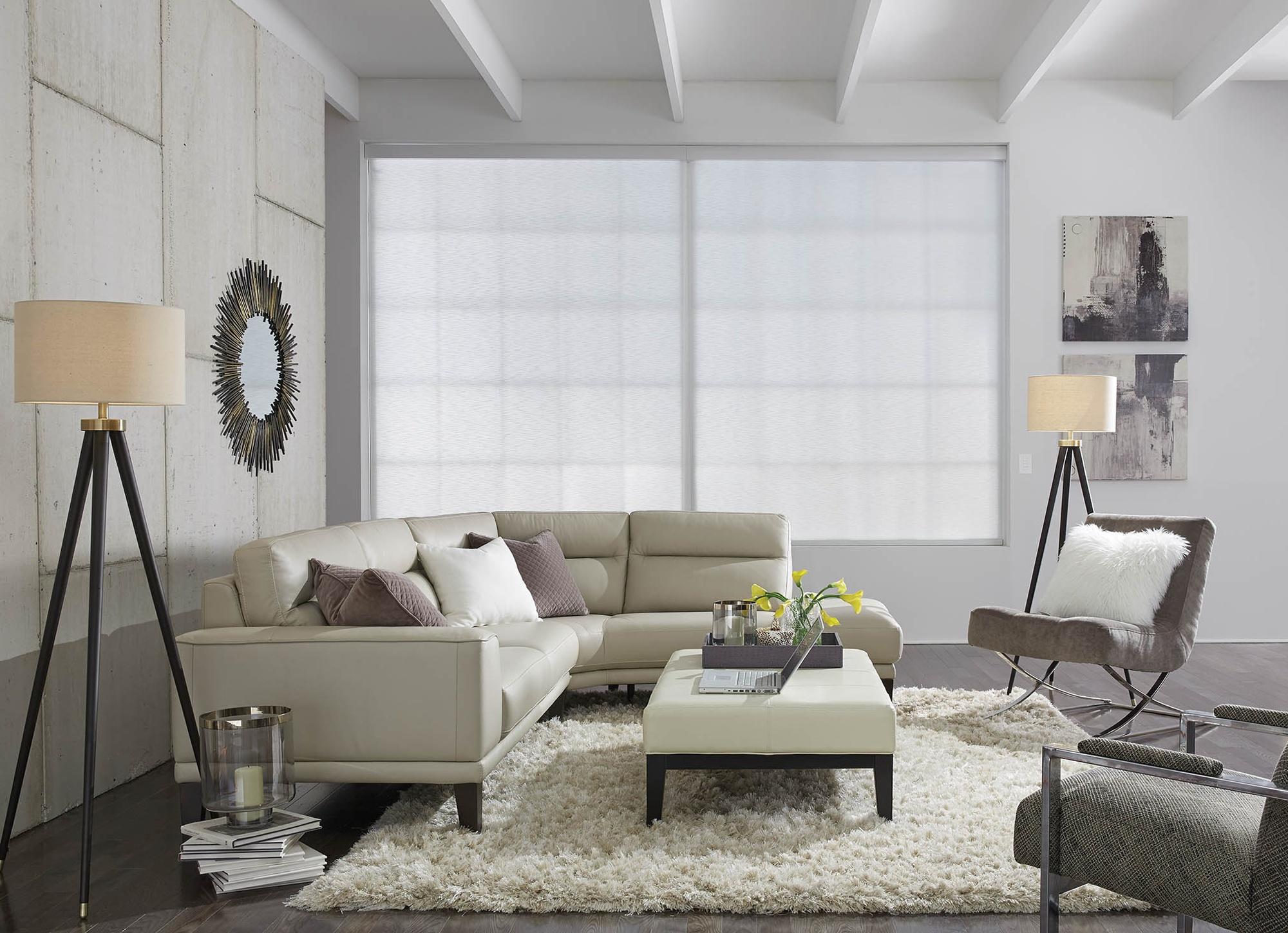 Bright living room with a white sectional sofa, floor lamps, and large windows letting in natural light.